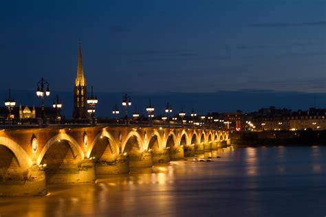 Vista nocturna del puente de piedra y la Basílica de San Miguel