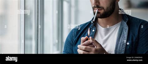 Young Man With Cigarette In Hand Feeling Lonely And Depressed