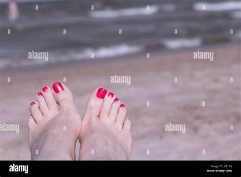 Beach Scene With Woman Feet On The Sand Nails Of Feet Painted Red