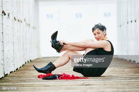 Older Caucasian Woman Taking Off Boots On Wooden Dock Photo Getty Images