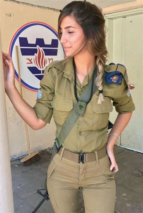 A Woman In Uniform Is Standing By A Wall And Holding Onto A Pole With