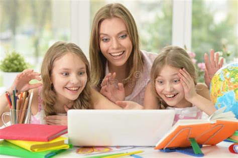 Happy Mother And Her Daughters Using Laptop At Home Stock Photo Image