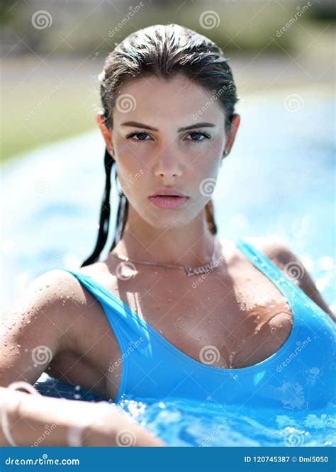 Beautiful Tanned Woman In Blue Swimwear Relaxing In Swimming Pool Spa Near Expensive Villa On