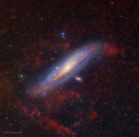 Andromeda Galaxy Behind Reddish Clouds Of Glowing Ionized Hydrogen Gas