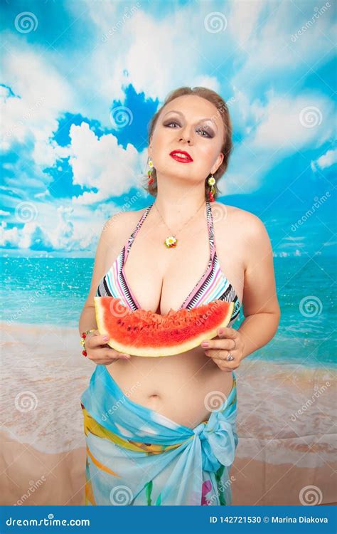Charming Plump Blonde With Big Breasts In A Swimsuit Stands With A