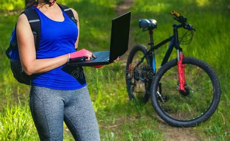 Girl Rides A Biker After A Trip To The Pine Forest And Makes A Further Route On The Laptop