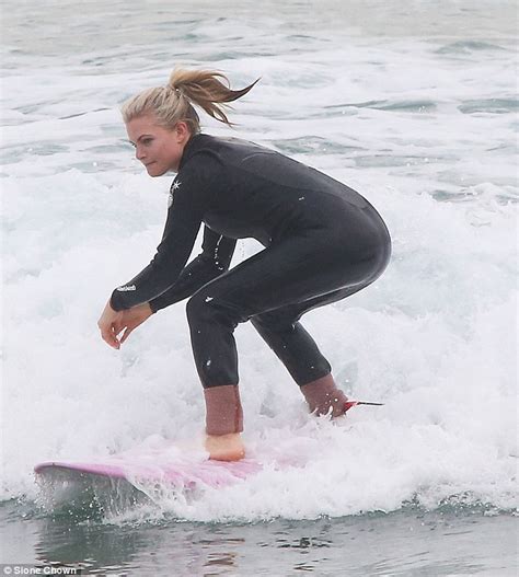 Home And Aways Bonnie Sveens Curvy Wetsuit Clad Figure In Surf