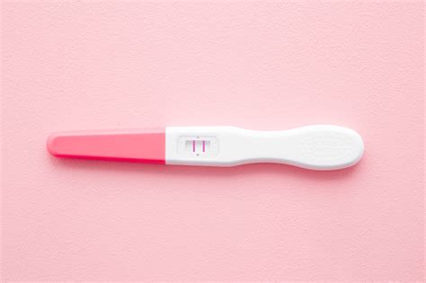 Pregnancy Test With Two Stripes On Pastel Pink Background Positive