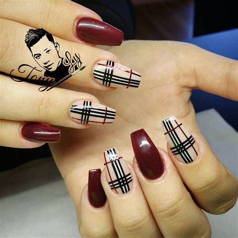 Stiletto nails, painted in smooth and bright, shiny red nail polish, accent nails decorated with black, white and red stripes, inspired by. Burberry | Burberry nails, Plaid nails, Nails