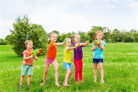 Kids Playing With Water Guns On A Meadow Stock Photo Image Of Guns