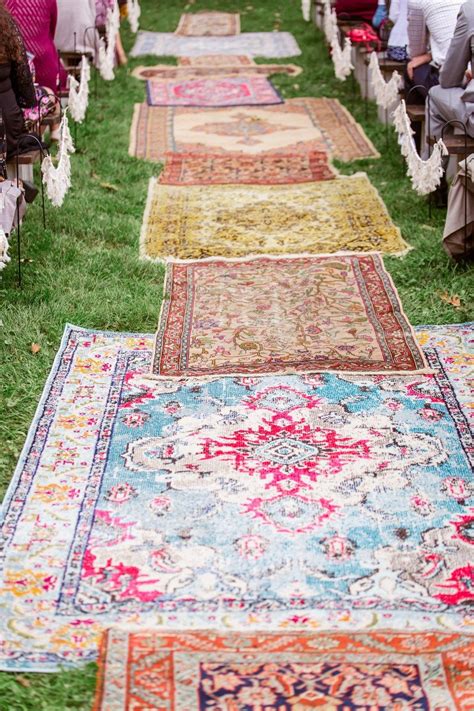 Rows Of Rugs Lined Up On The Grass At An Outdoor Wedding Ceremony With