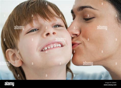 Mother Kissing Boy S Cheek Stock Photo Alamy