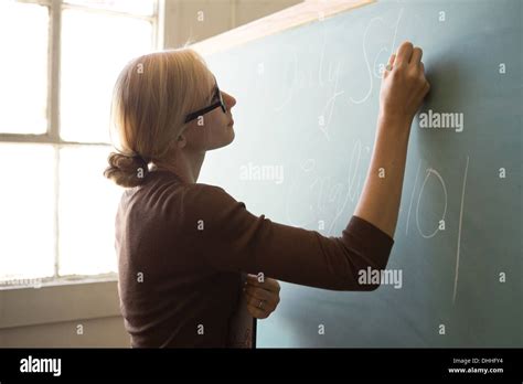 Teacher Writing On Blackboard With Chalk Stock Photo Alamy
