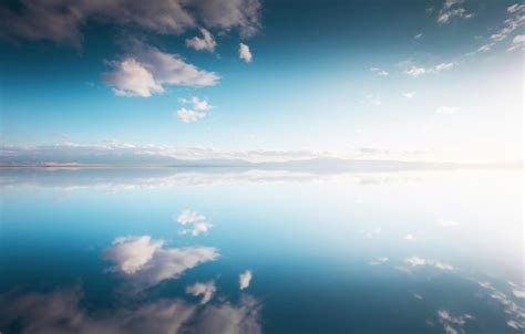 Un Cielo Azul Con Nubes Y El Sol Se Refleja En El Agua Foto Premium