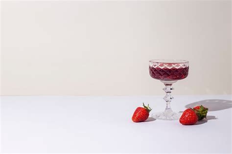 Premium Photo Glass With Red Wine And Strawberries On The Table On A Light Background