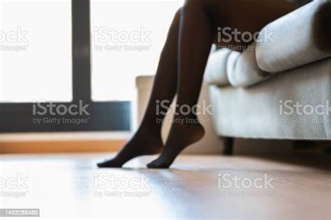 Defocused Crop Young Woman In Black Stockings Sitting On The Sofa Stock