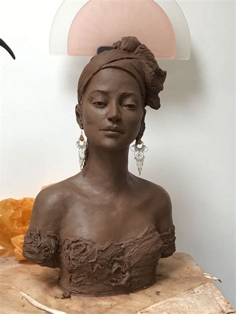 A Clay Sculpture Of A Woman S Head With Her Eyes Closed On A Piece Of Wood