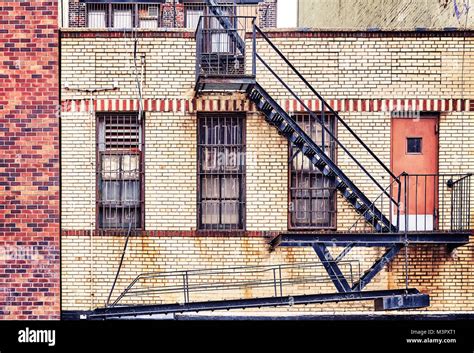 Vintage Toned Picture Of An Old Brick Building With Fire Escapes