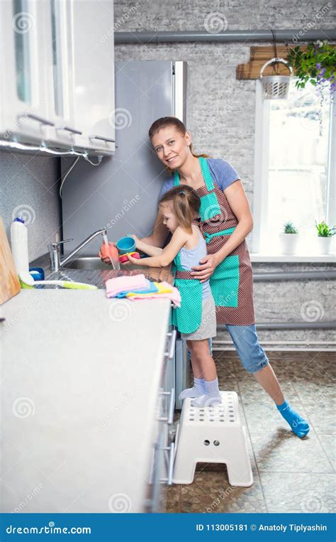 Madre E Hija En Casa En Los Platos Que Se Lavan De La Cocina Imagen De