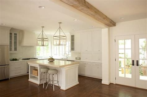 An ergonomic furnishing solution for a spacious kitchen with a modern design. L shaped kitchen features a white plaster range hood over ...