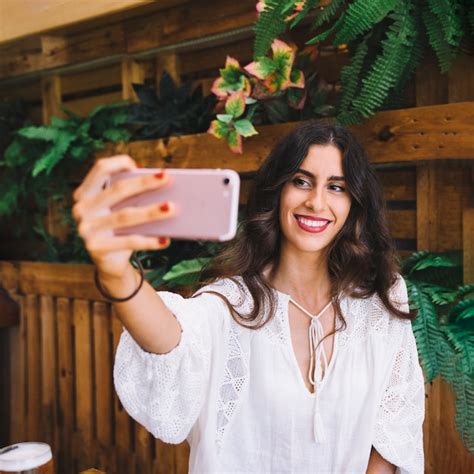 mujer haciendo selfie con smartphone rosa foto gratis