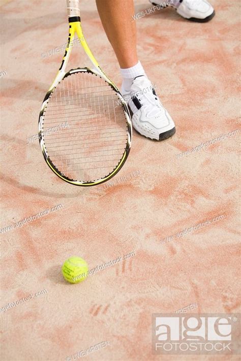 Man Holding Tennis Racket Ball On Ground Stock Photo Picture And Royalty Free Image Pic Wes