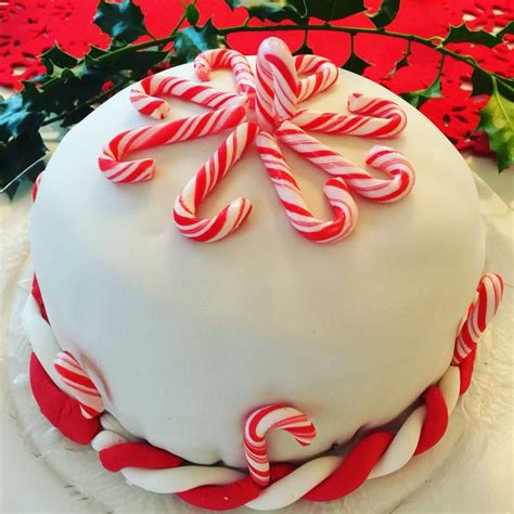 A Large White Cake With Candy Canes On Top