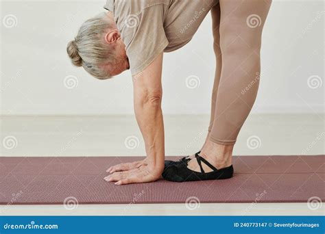 Side View Of Senior Active Woman In Beige Leggins And T Shirt Bending
