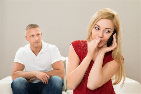 wife talking on mobile phone while husband on sofa stock image image of listening jealousy