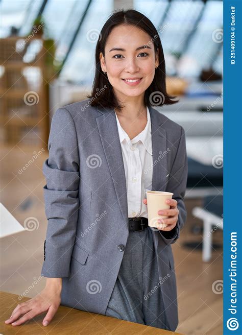 Young Smiling Asian Business Woman Standing In Office Vertical