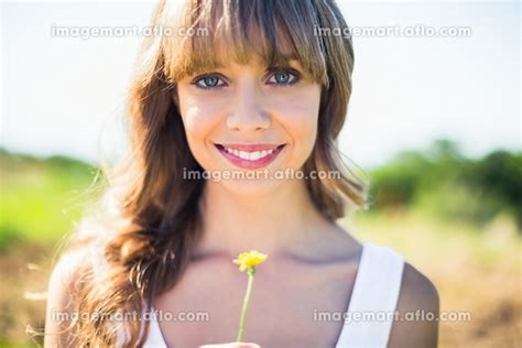 Smiling Natural Blonde Holding Dandelion Looking At Camera On A Summers