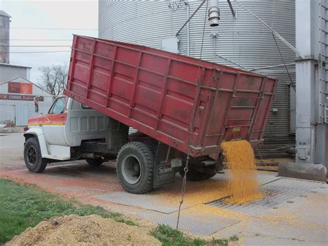 A Dump Truck Is Dumping Grain Into A Silo