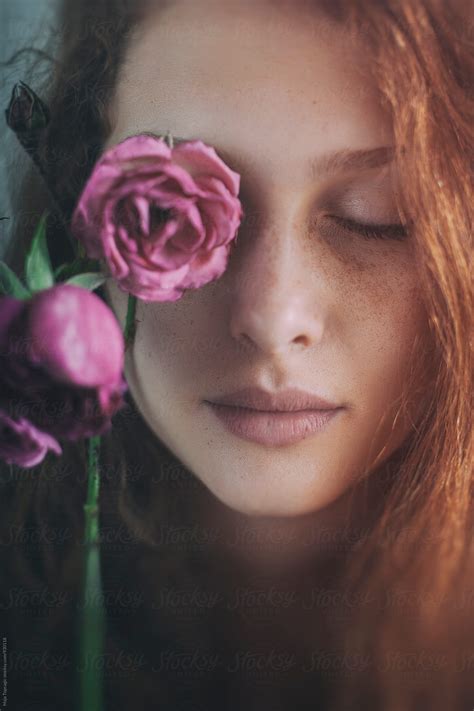 Portrait Of A Beautiful Redhead With Freckles Holding A Rose By