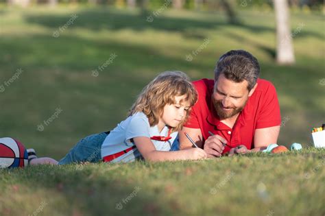 Padre E Hijo Se Relajan En La Hierba En El Parque Aprendiendo A Dibujar