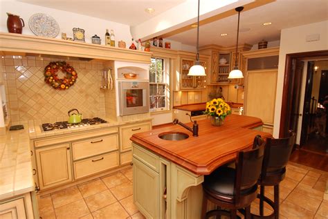 This kitchen was designed to accommodate an enthusiastic cook and entertainer who wanted a contemporary feel that would not be at odds crisp white cabinets brighten dark brown subway tile walls in this transitional kitchen. Warm Farmhouse Kitchen - Cabinets by Graber