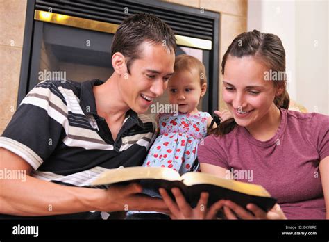 Una Joven Familia Cristiana Leyendo La Biblia Juntos Fotografía De