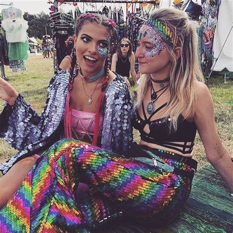 Two Women Sitting On The Ground With Their Faces Painted Like Mermaid