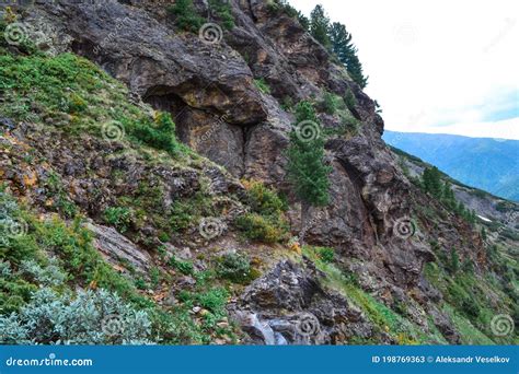 Mountain Stones Rocky Slope Overgrown With Moss Grass Bushes And Trees