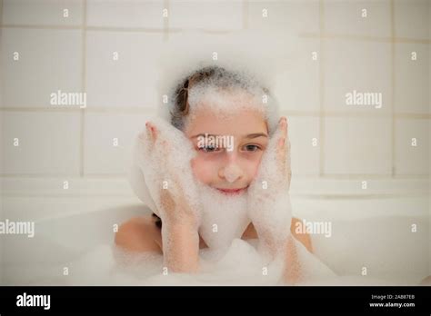 Junge Mädchen In Der Badewanne Ein Kleines Mädchen Taucht In Der Badewanne Mit Schaum Ein