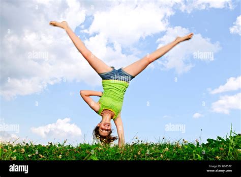 Young Teenage Girl Doing Cartwheel In A Summer Meadow Stock Photo Alamy