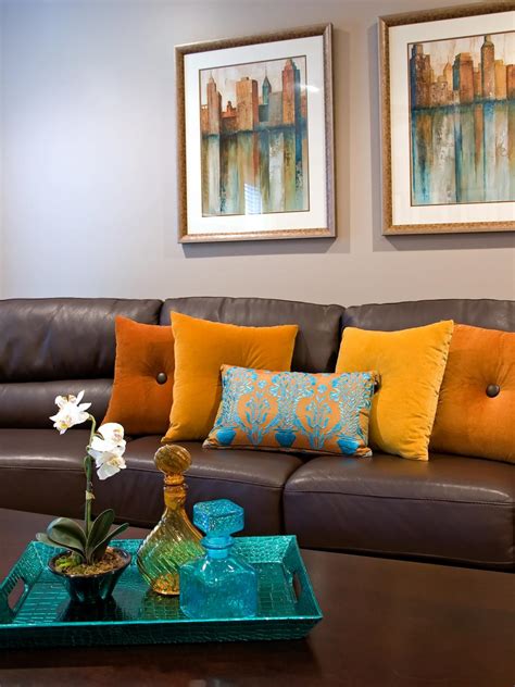 Edge trim and fine artisan details. Contemporary Brown Leather Sofa With Orange Throw Pillows | HGTV