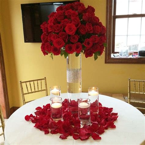 Red Rose Atop A Clear Glass Diamond Banded Cylinder Surrounded By