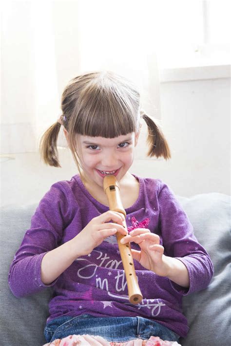 Little Girl Playing Recorder At Home Stock Photo