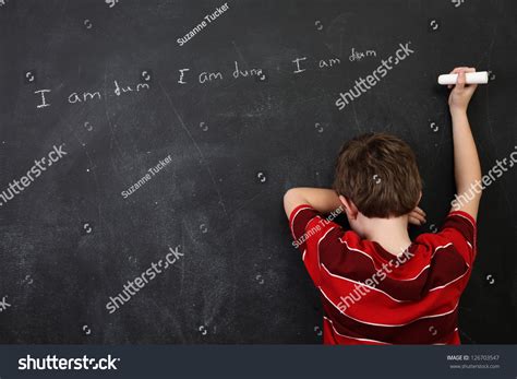 Boy With Poor Spelling And Low Self Esteem Writing On A Blackboard