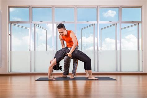 Yoga Instructor Assisting Student Perform Backbend Or Chakrasana Pose