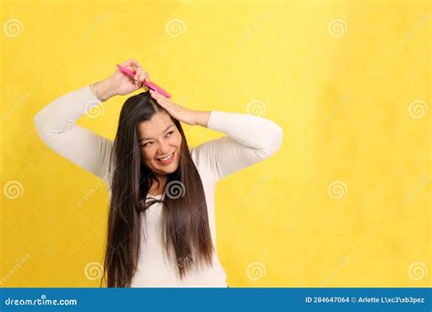 40 Year Old Latina Woman Brushes Her Straight Hair With Difficulty Because It Is Already Too