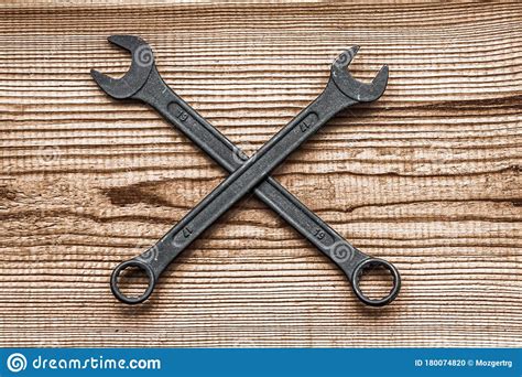 Black Steel Wrenches Lies By Crosswise Layout On Dark Brown Wood