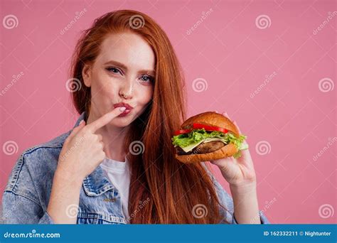 beautiful redhaired ginger redhead woman holding big huge cheeseburger with cheese beef cutlet