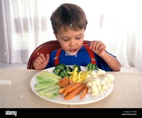 Little Boy Eating Raw Vegetables Stock Photo Alamy