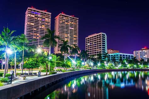 Palm Trees Along The Intracoastal Waterway And The Skyline At Night In